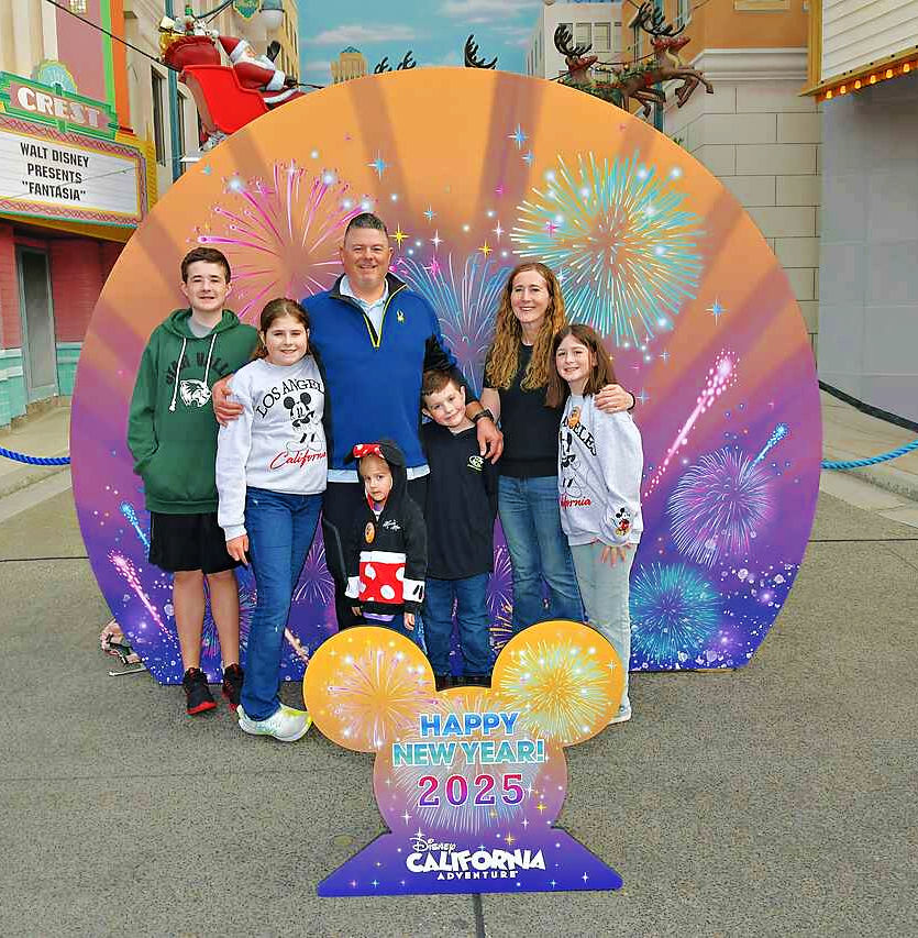 A photo of the Dean family in front of a photo backdrop at DCA.